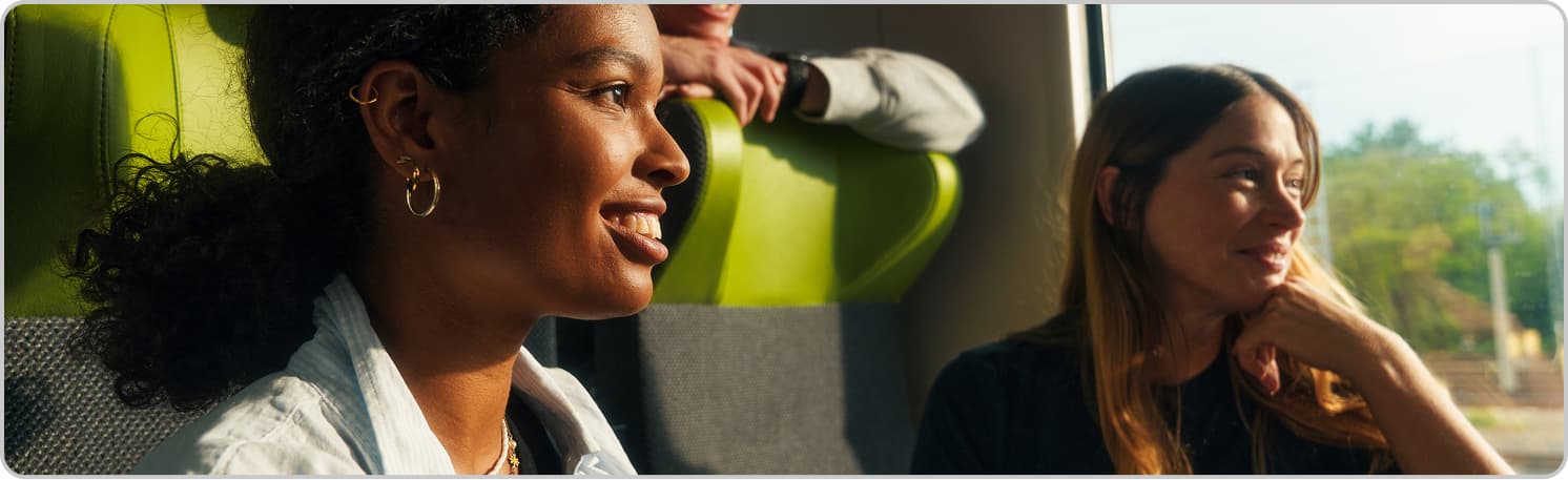 Two smiling travelers in a FlixBus vehicle.
